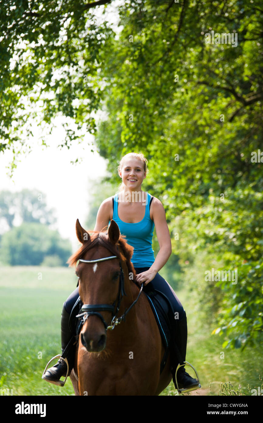 Smiling teenage girl riding horse Stock Photo