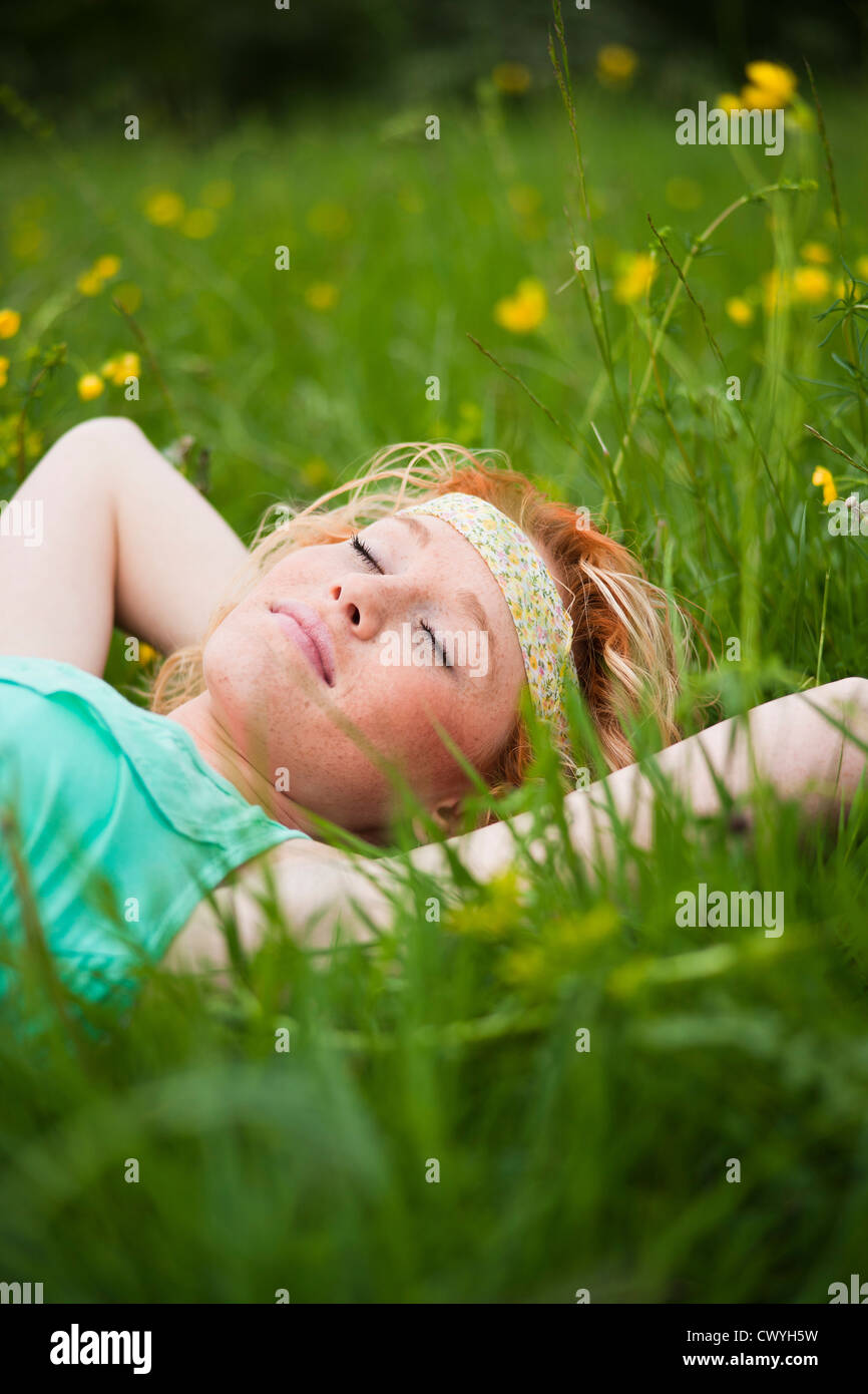 Young woman with closed eyes lying in meadow Stock Photo - Alamy