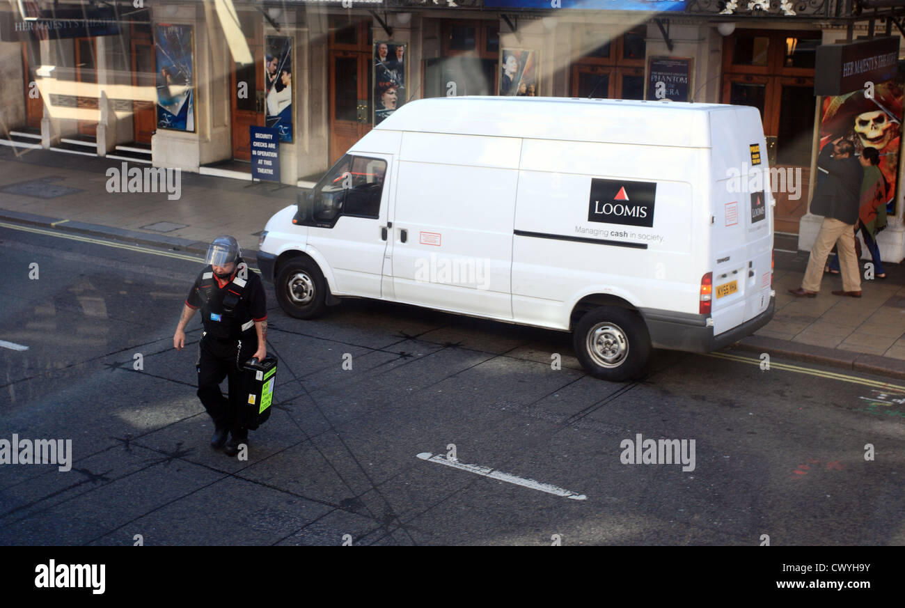 Guard takes money across road from a security van. Stock Photo