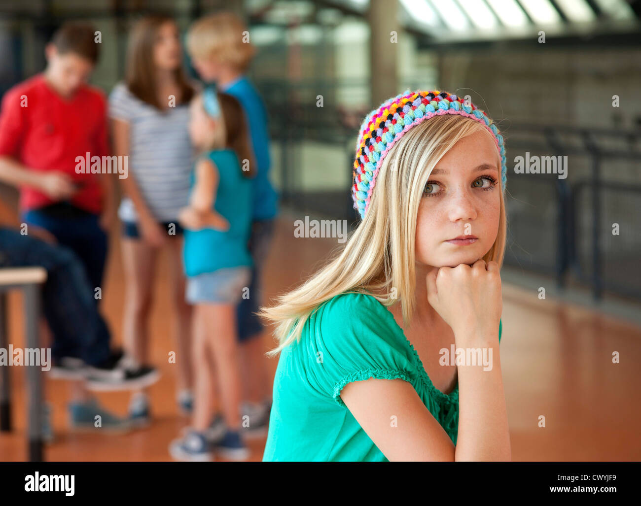 Serious teenage girl in front of group of schoolchildren Stock Photo