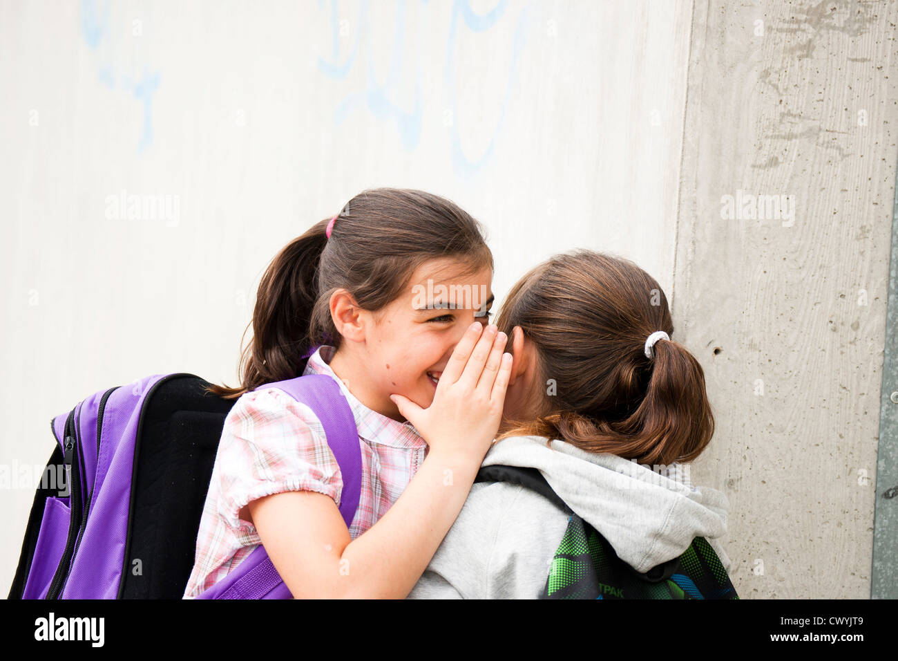 Two happy girls whispering Stock Photo - Alamy