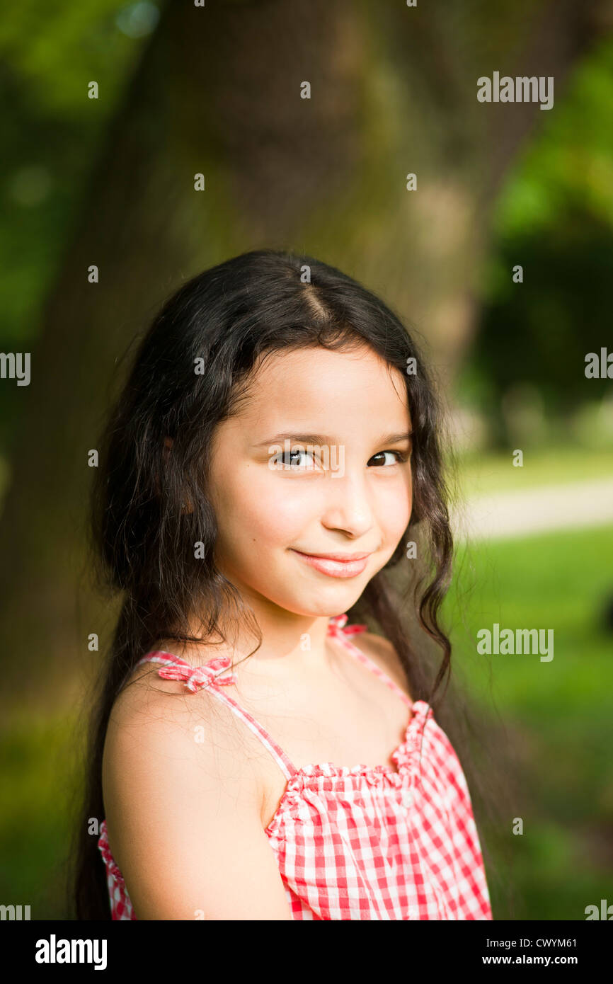 Smiling dark-haired girl outdoors, portrait Stock Photo