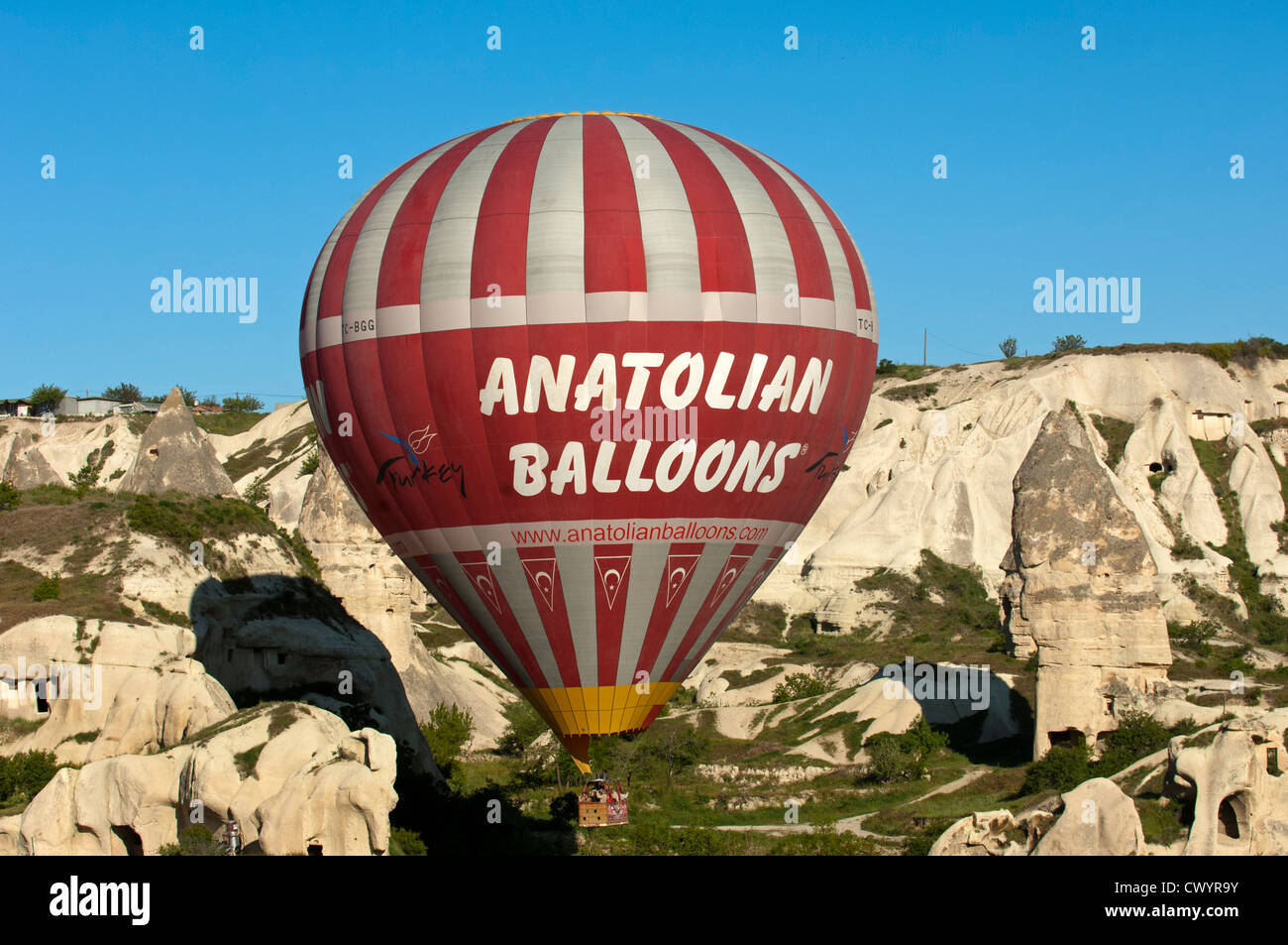 Hot air balloon of Anatolian Balloons landing in a tuffa rock site of Cappadocia, Göreme, Turkey Stock Photo