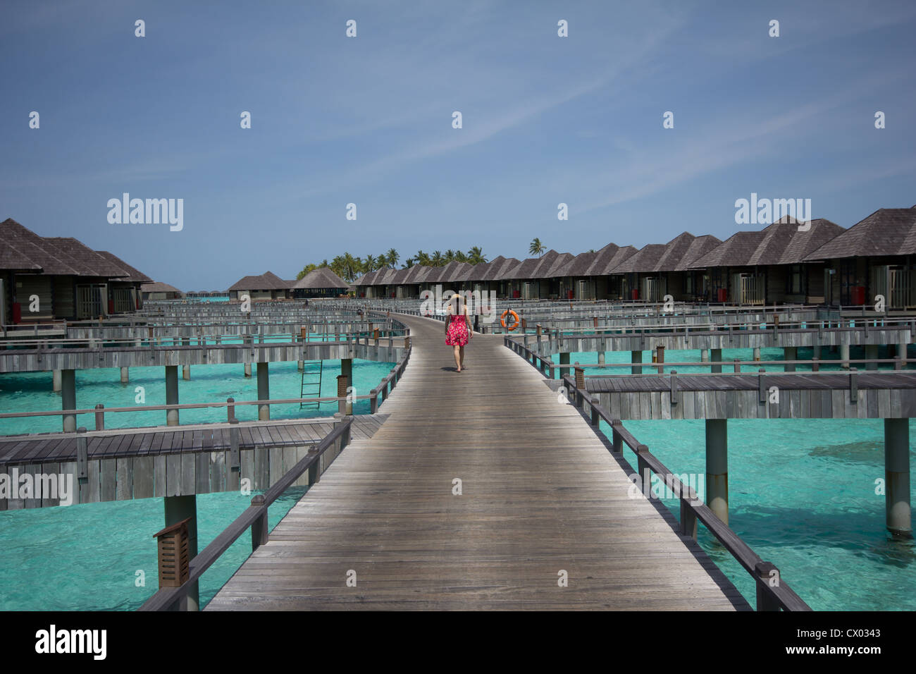 Girl walking on wooden deck - Maldives - Stock Image