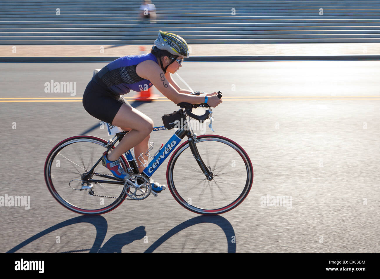 Female cyclist racing on road (bike race, bicycle racing, bike racer) - USA Stock Photo