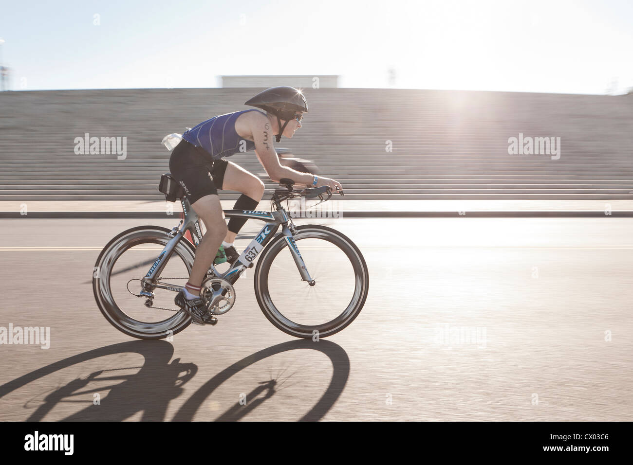 Cyclist racing in bright sun light - USA Stock Photo