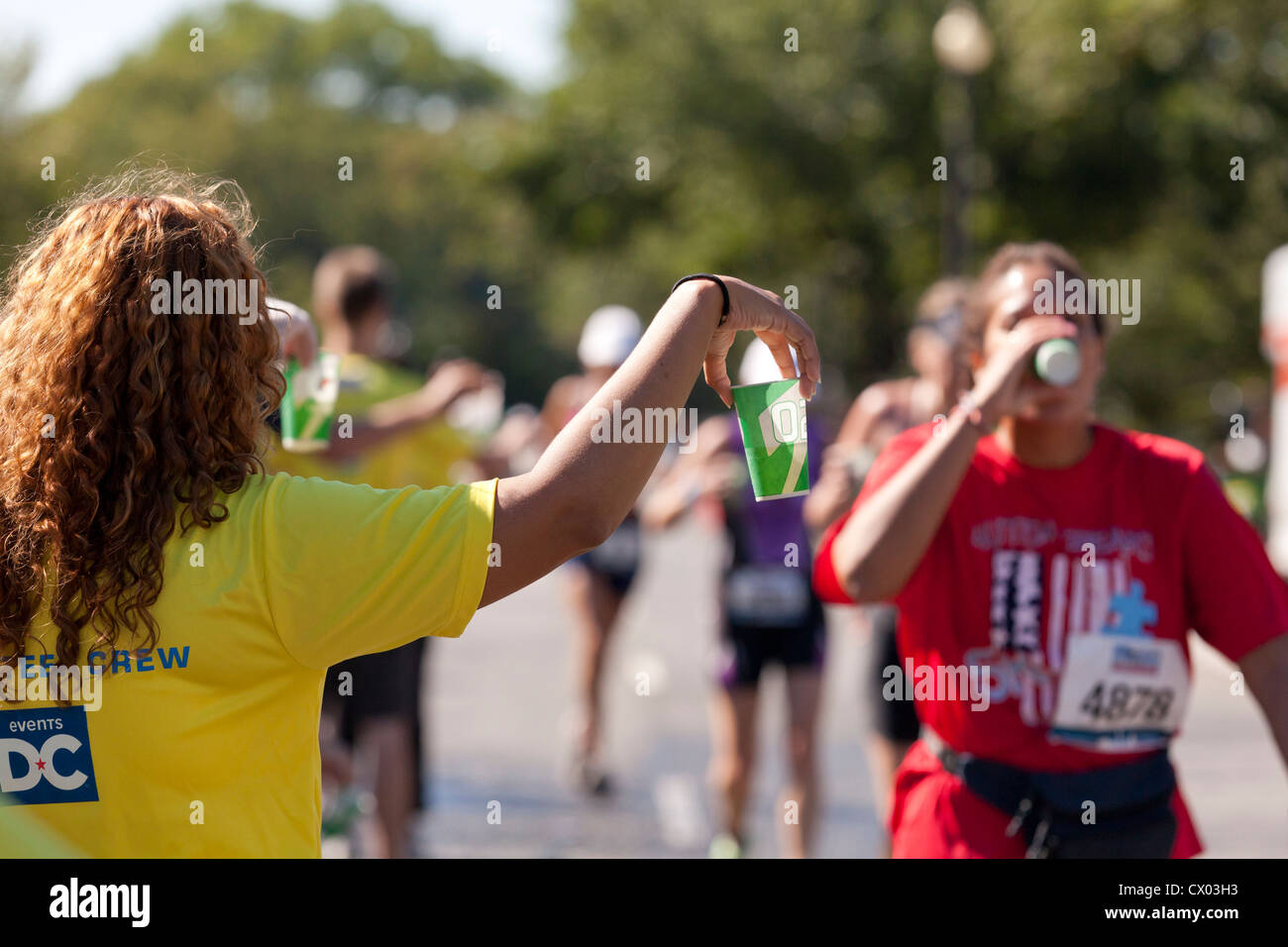 Marathon volunteer offering water to runners - USA Stock Photo