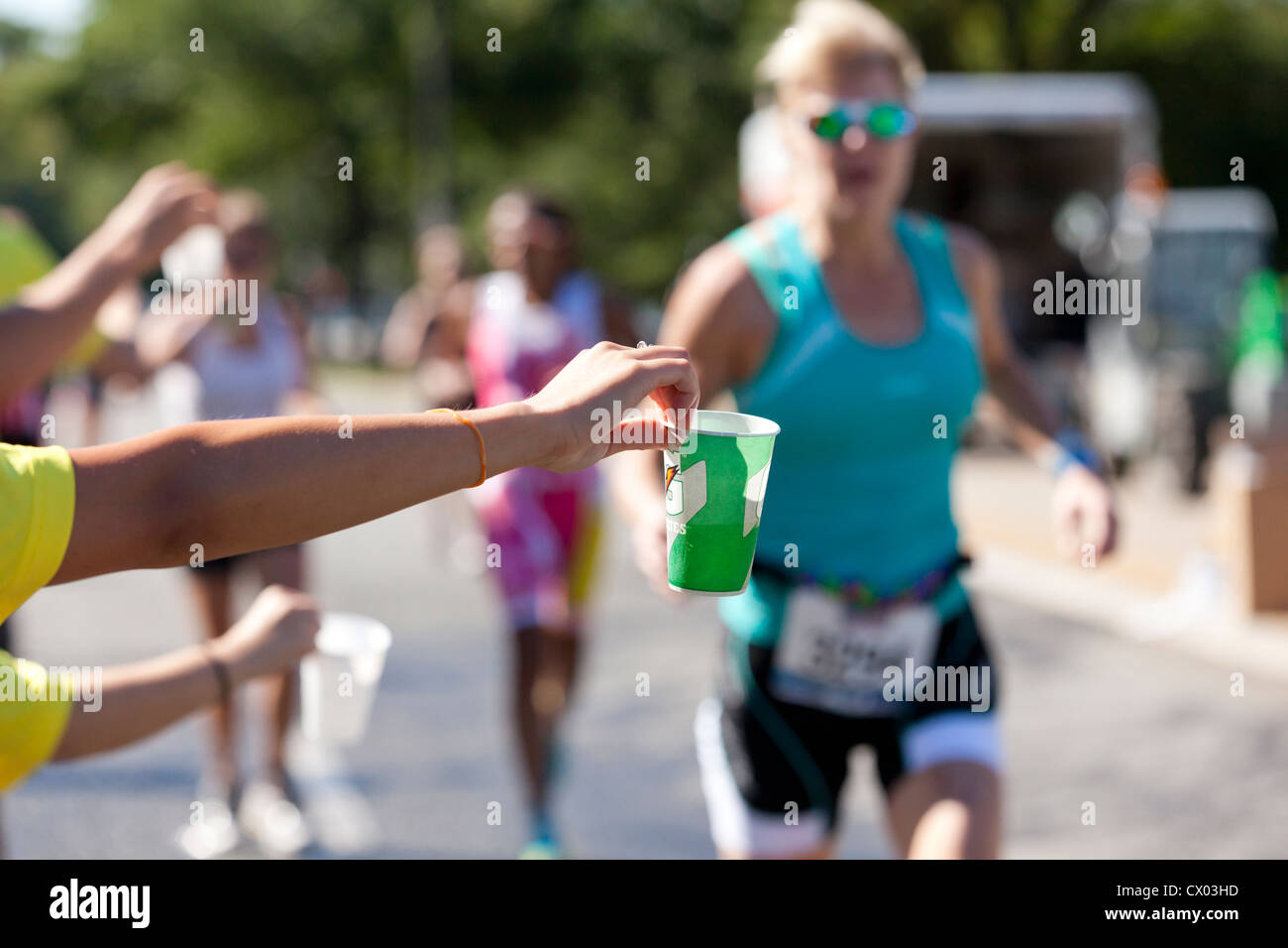 Marathon volunteer offering water to runners USA Stock Photo Alamy
