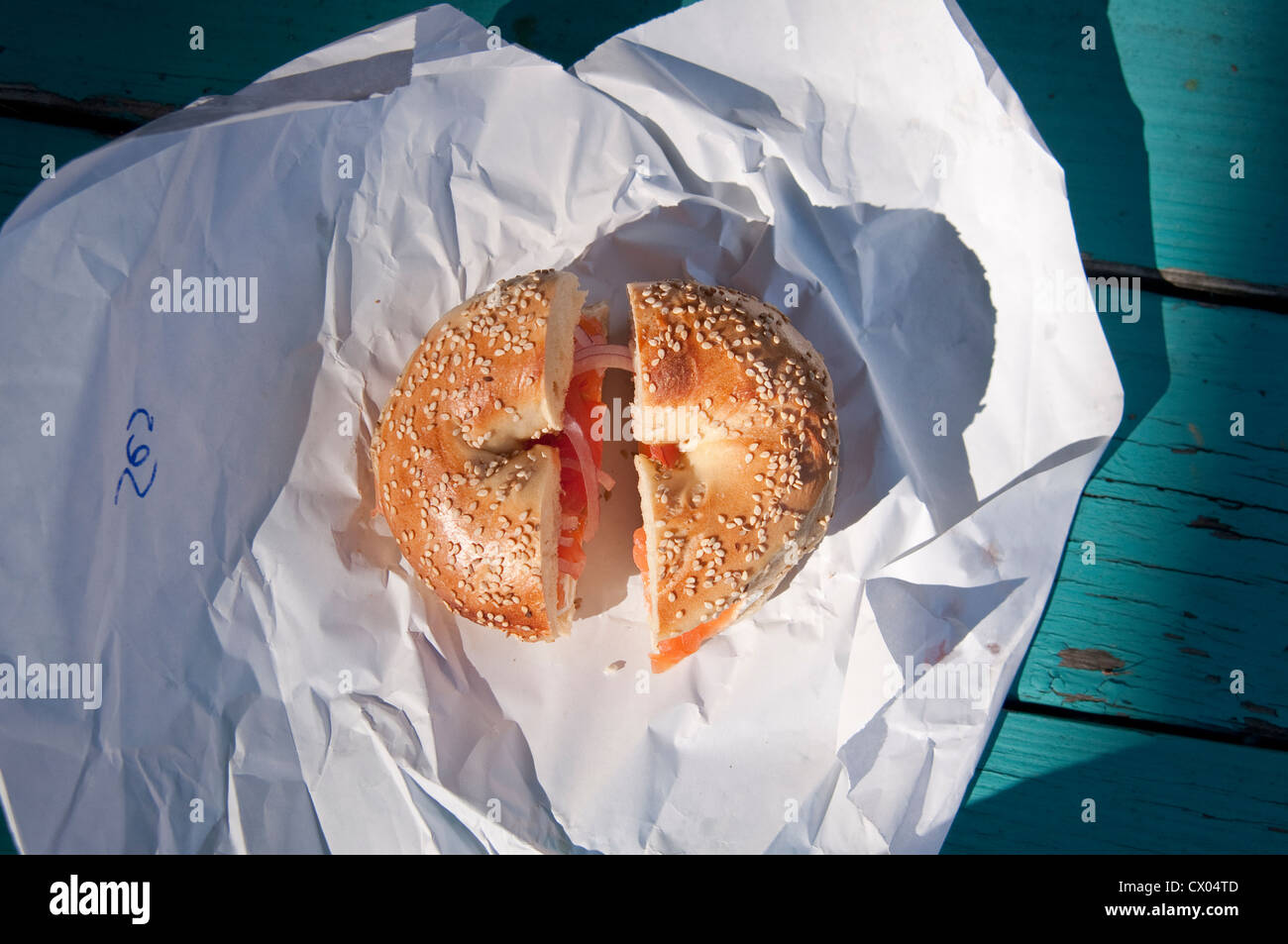A sesame seed bagel with lox (smoked salmon), cream cheese, onion and