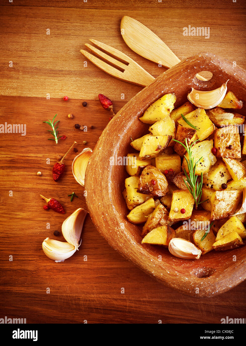 Picture of fried potato with garlic and spices on wooden table, baked