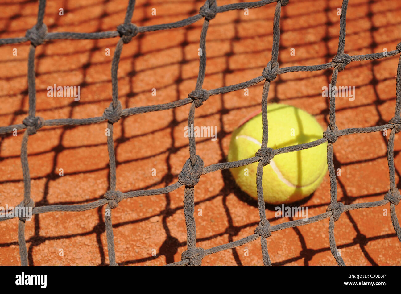 Tennis ball behind the net Stock Photo Alamy