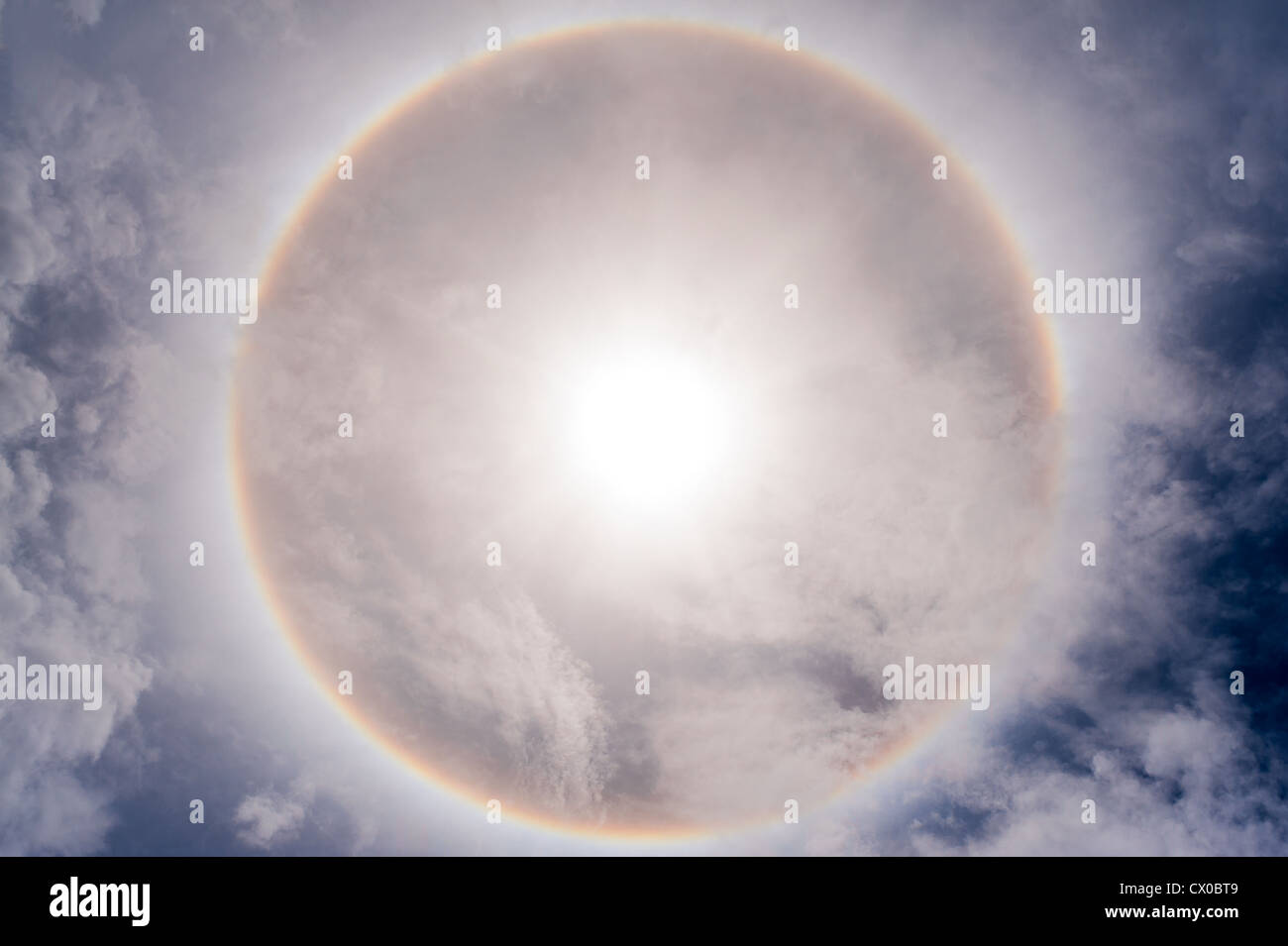 Sun with circular rainbow sun halo in sky with cloud Stock Photo