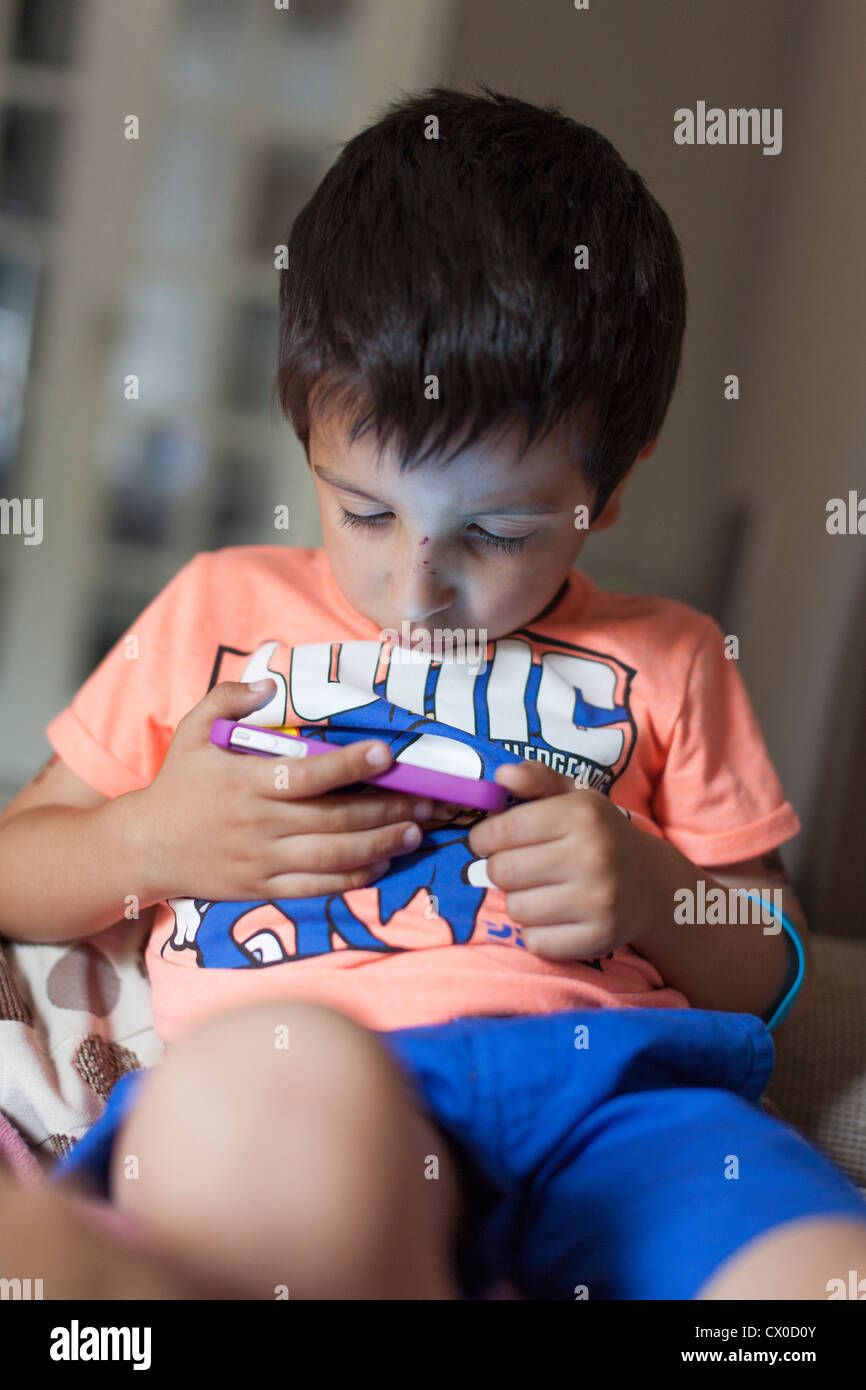 young boy plays games on mobile phone Stock Photo