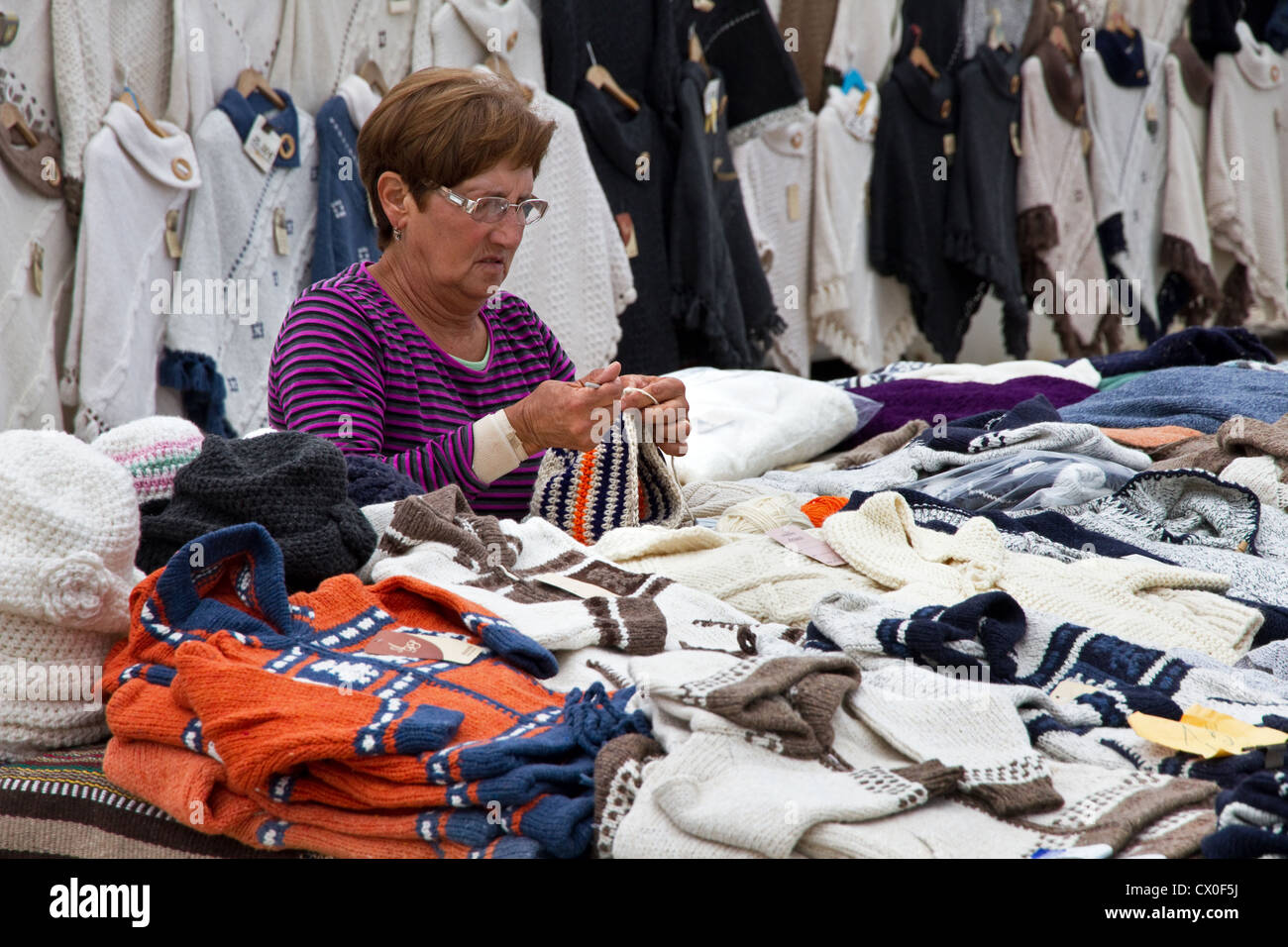 Woman knitting on knitwear stall, Cape Saint Vincent, Algarve, Portugal Stock Photo