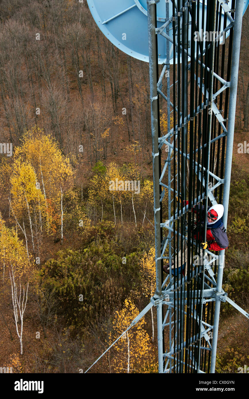 Climber on cell tower - seen from neighboring structure. Stock Photo