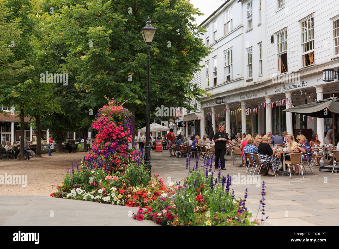 Street scene with flowerbeds and people dining outside Woods restaurant on the Pantiles, Royal Tunbridge Wells, Kent, England, UK Stock Photo