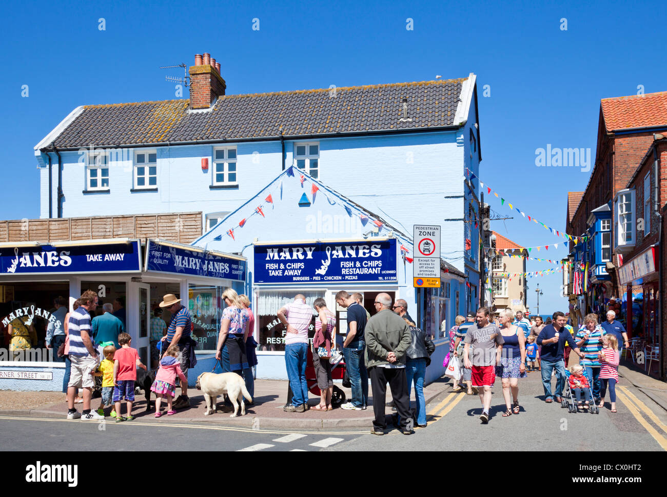 Queue of tourists outside a popular Fish and Chip shop cafe restaurant in the centre of Cromer Norfolk England UK GB Europe Stock Photo