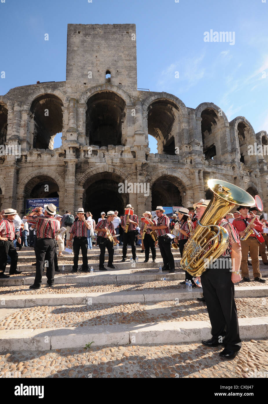 Brass band on the steps of the Roman arena in Arles France with tuba in foreground Stock Photo