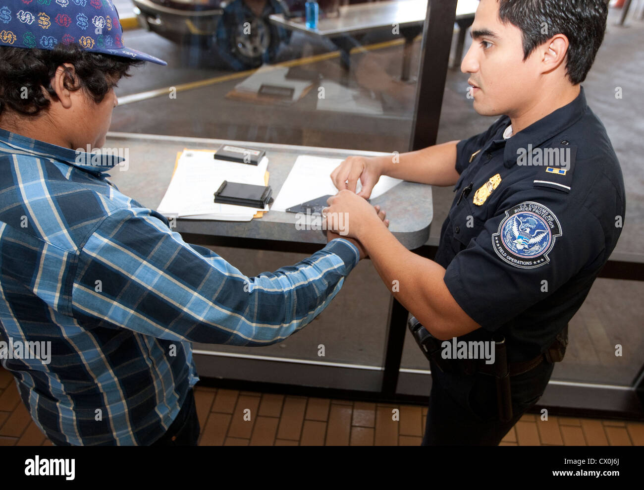 Mexican citizens wait  fill out paperwork to travel to the US. Security measures include fingerprinting by US Border Patrol Stock Photo