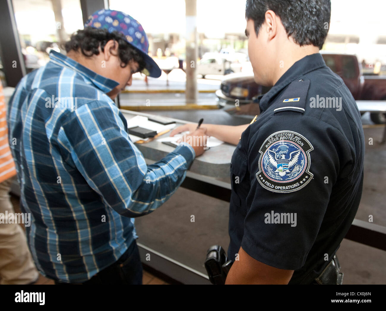 Mexican citizens wait  fill out paperwork to travel to the US. Security measures include fingerprinting by US Border Patrol Stock Photo