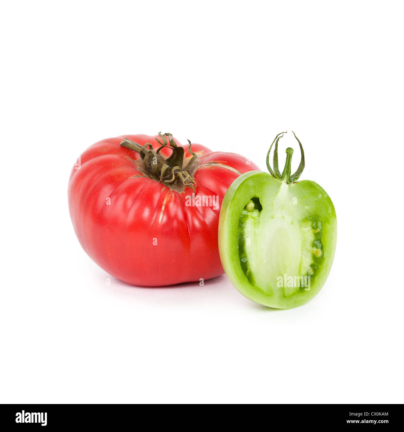Red tomato and half of green tomato closeup on white background Stock ...