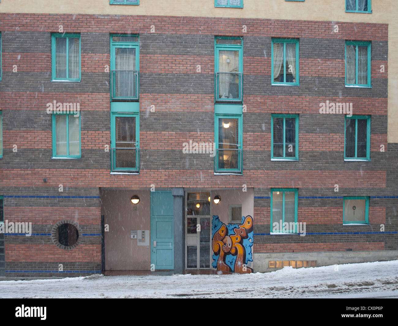 Snowfall in downtown Oslo residential area. Apartment house with colorful details, graffiti and slippery pavement Stock Photo
