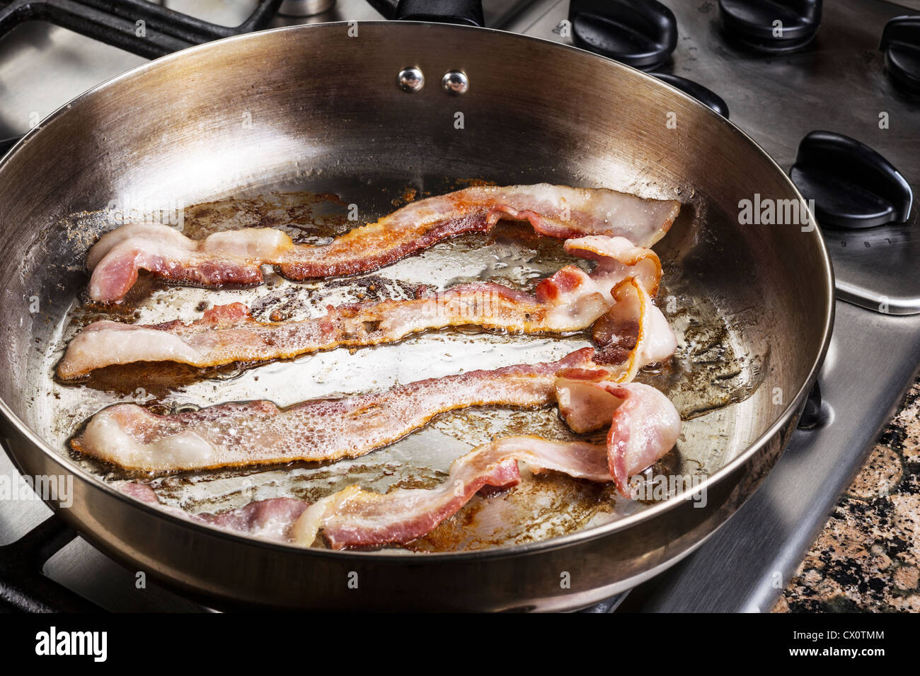 https://c8.alamy.com/comp/CX0TMM/frying-bacon-in-stainless-steel-frying-pan-on-stove-top-CX0TMM.jpg