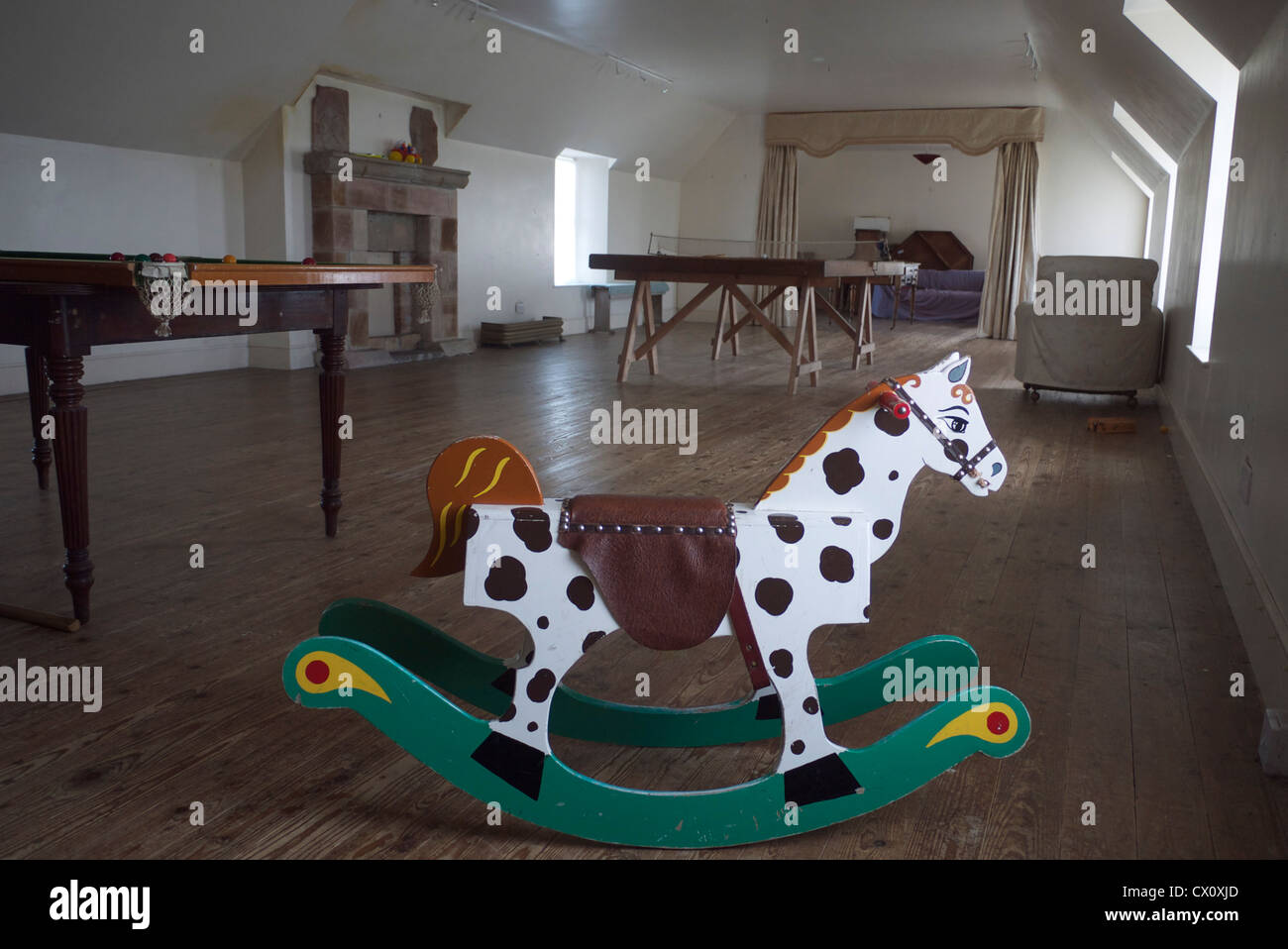 a rocking horse in an attic playroom of an old house Stock Photo