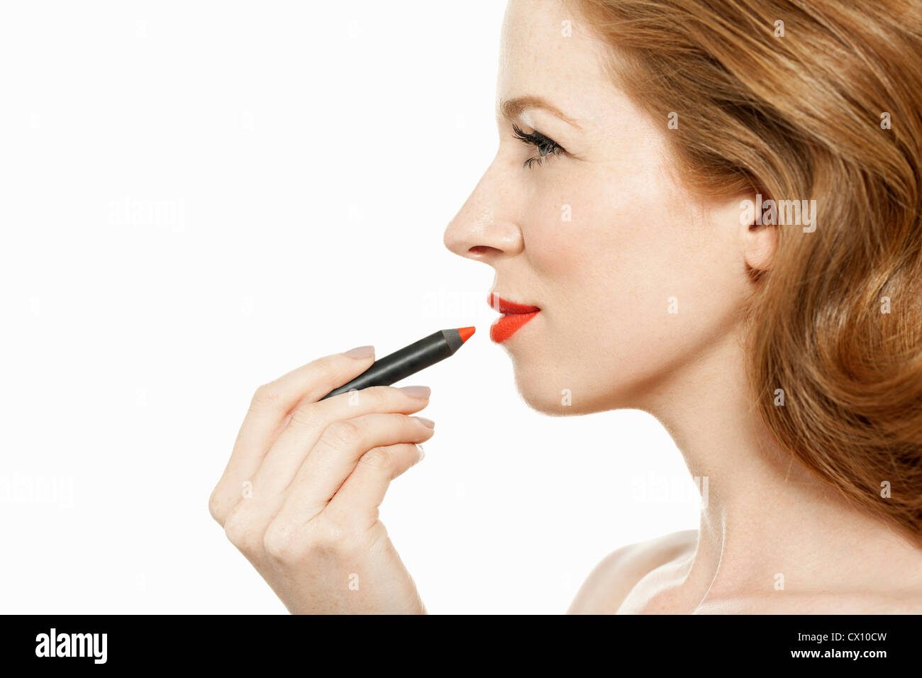 Woman applying red lipstick Stock Photo