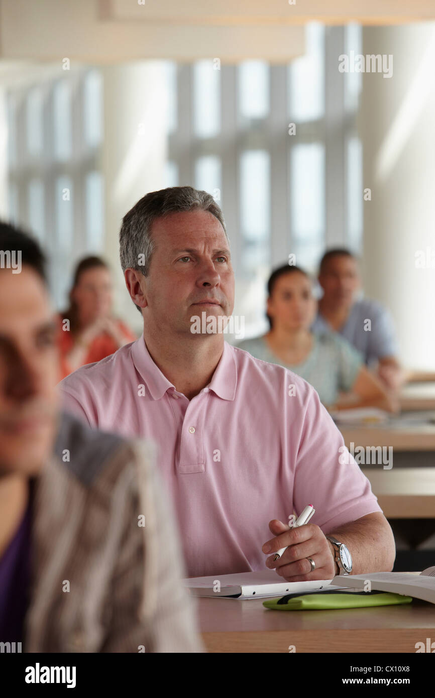 Mature students in class, man making notes Stock Photo