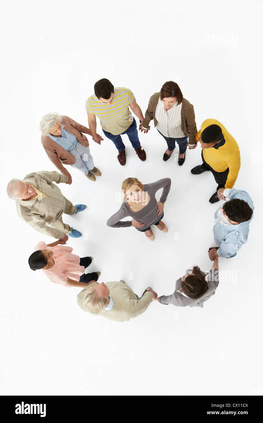 Group of people in a circle with woman in the middle, high angle view Stock Photo