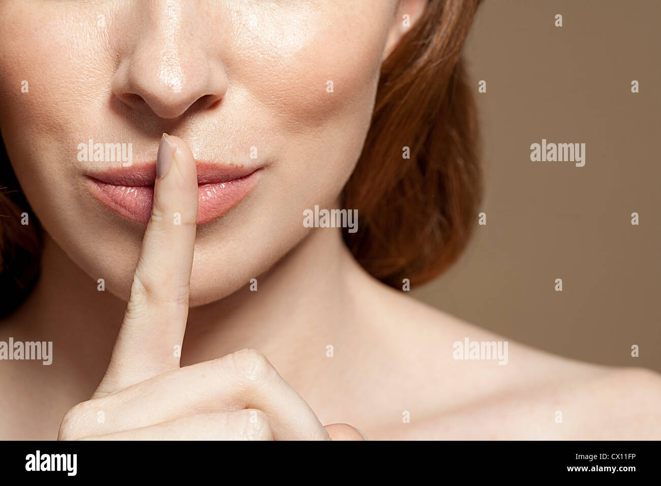 Woman with finger on lips, close up Stock Photo