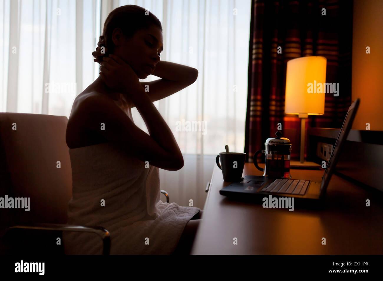 Young woman sitting at laptop in hotel room Stock Photo Alamy