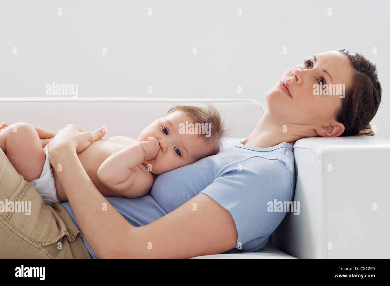 Mother and baby girl on sofa Stock Photo - Alamy