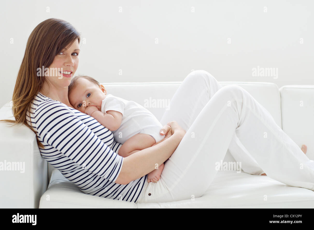 Mother and baby girl on sofa Stock Photo - Alamy