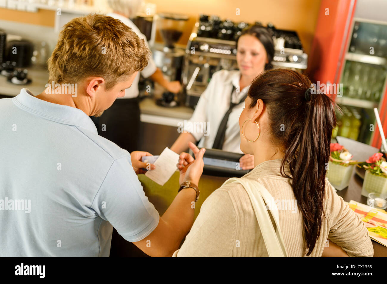Man checking receipt at cafe restaurant payment waitress couple bar Stock Photo