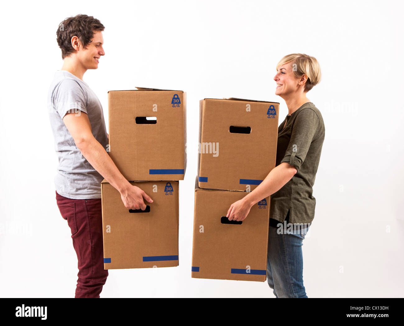 Symbolfoto Umzug, Auszug, umziehen. Junges Paar trägt Umzugskartons. Umzugskisten aus Pappkarton. Stock Photo