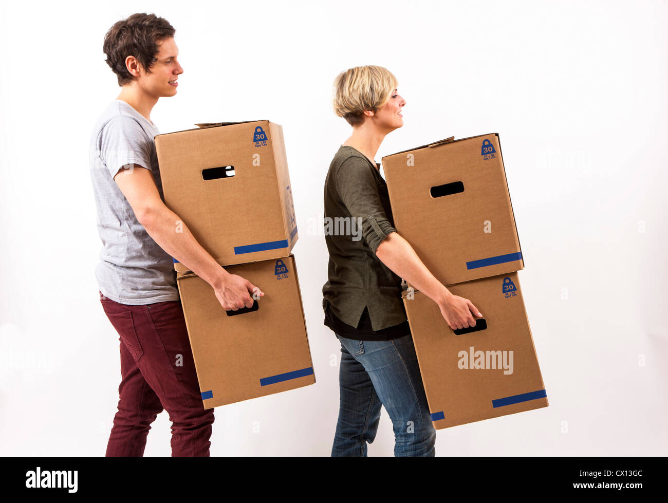 Symbolfoto Umzug, Auszug, umziehen. Junges Paar trägt Umzugskartons. Umzugskisten aus Pappkarton. Stock Photo