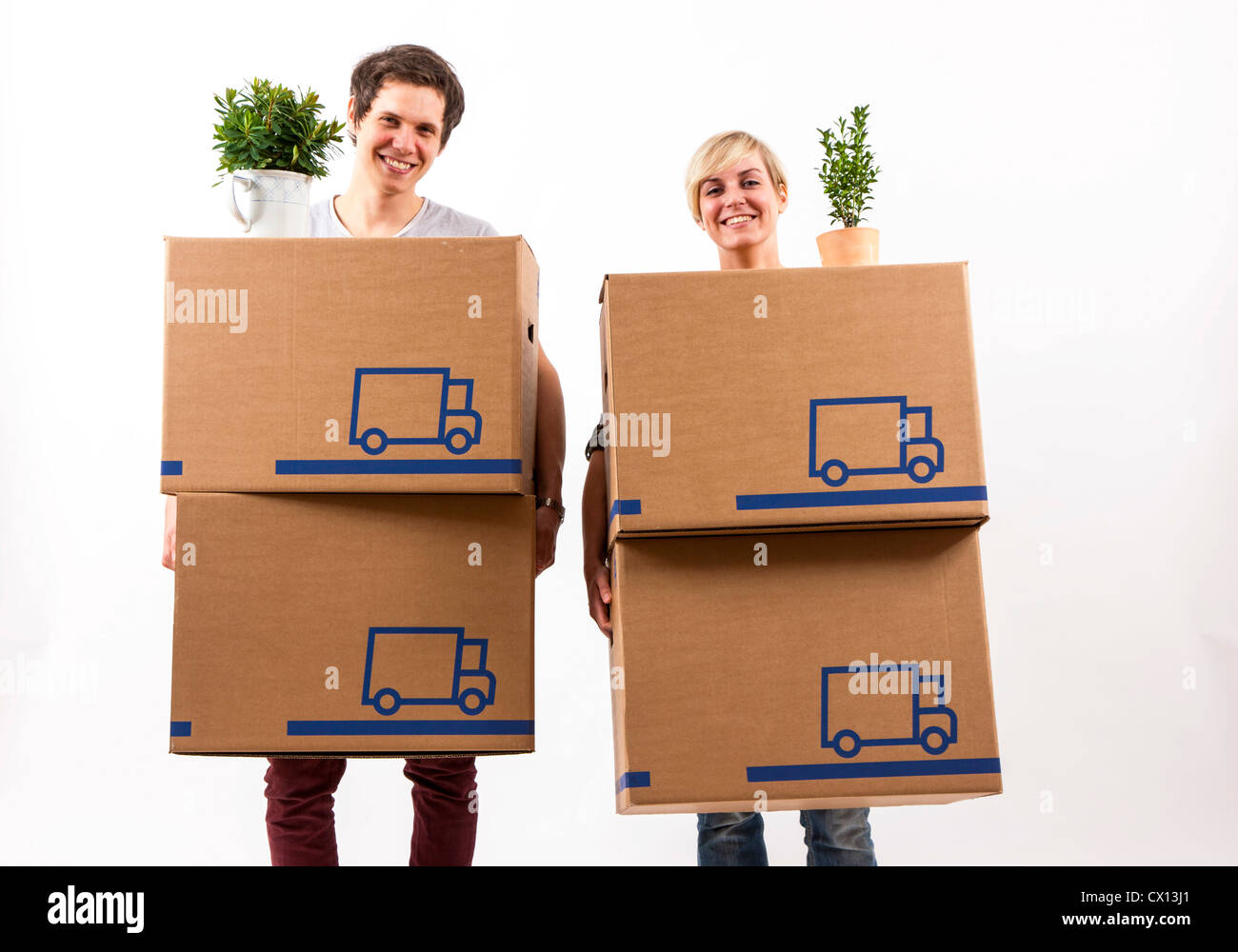 Symbolfoto Umzug, Auszug, umziehen. Junges Paar trägt Umzugskartons und Zimmerpflanze. Umzugskisten aus Pappkarton. Stock Photo