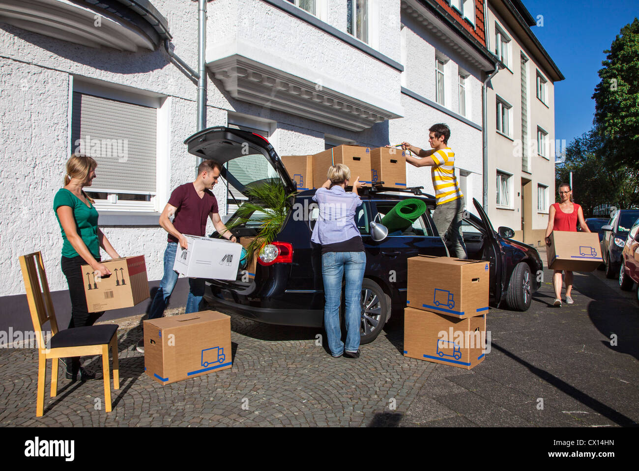 Moving. Young people moving from one home into a new one. Carrying