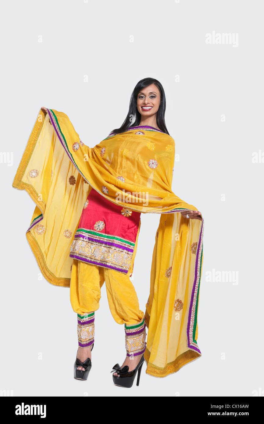 Full length of an Indian woman in salwar kameez standing over gray background Stock Photo