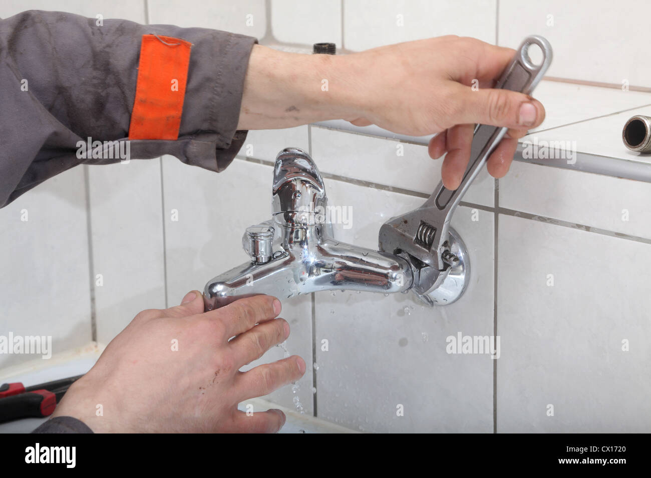 Plumber hands fixing water tap with spanner Stock Photo Alamy