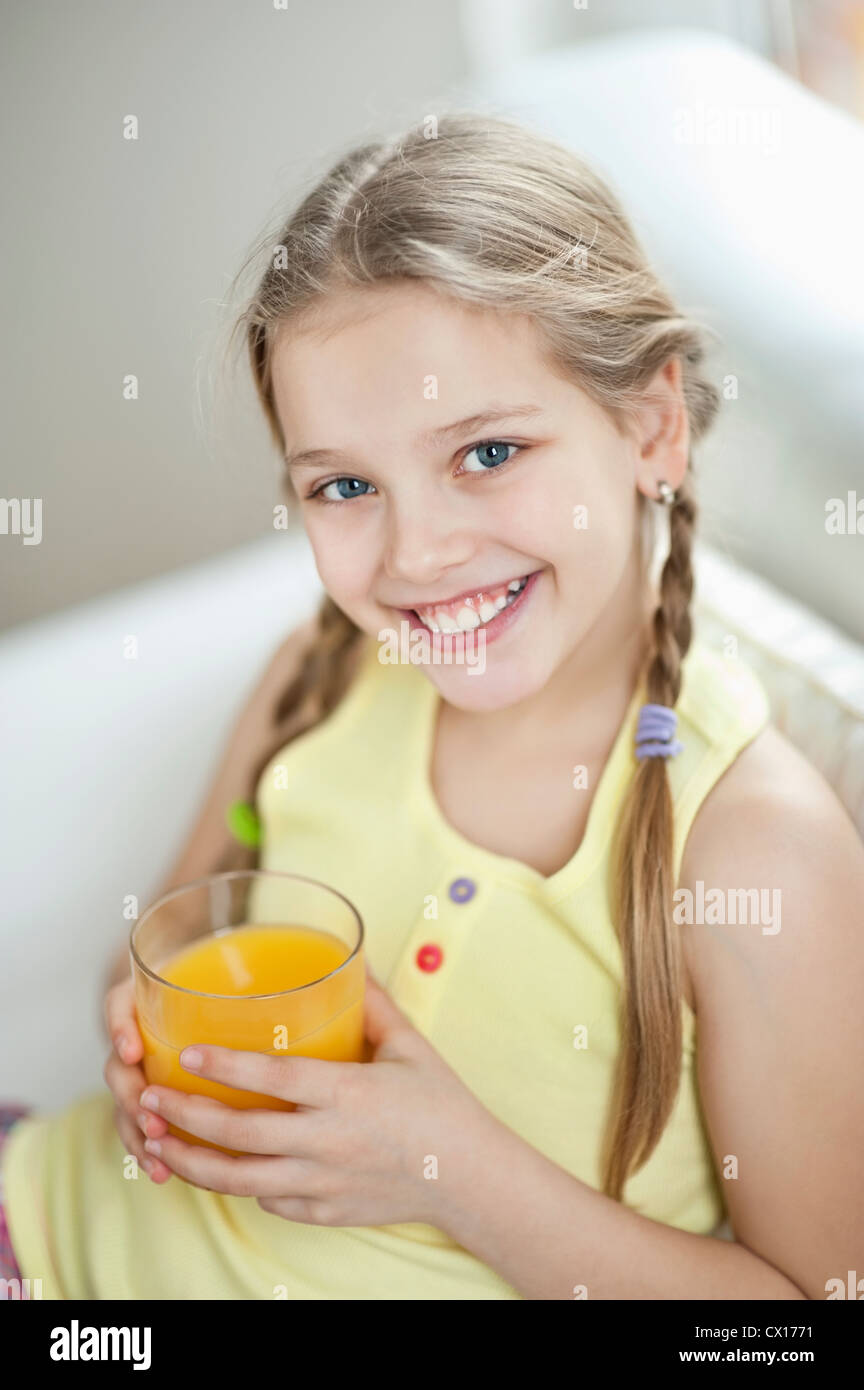 Portrait of girl drinking orange juice Stock Photo - Alamy