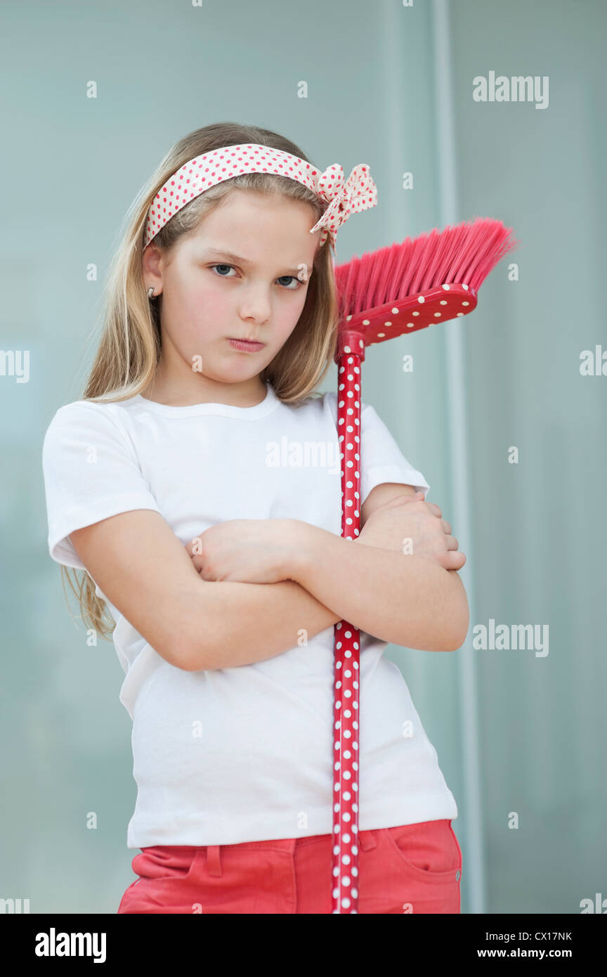 Portrait of an angry girl with broom Stock Photo