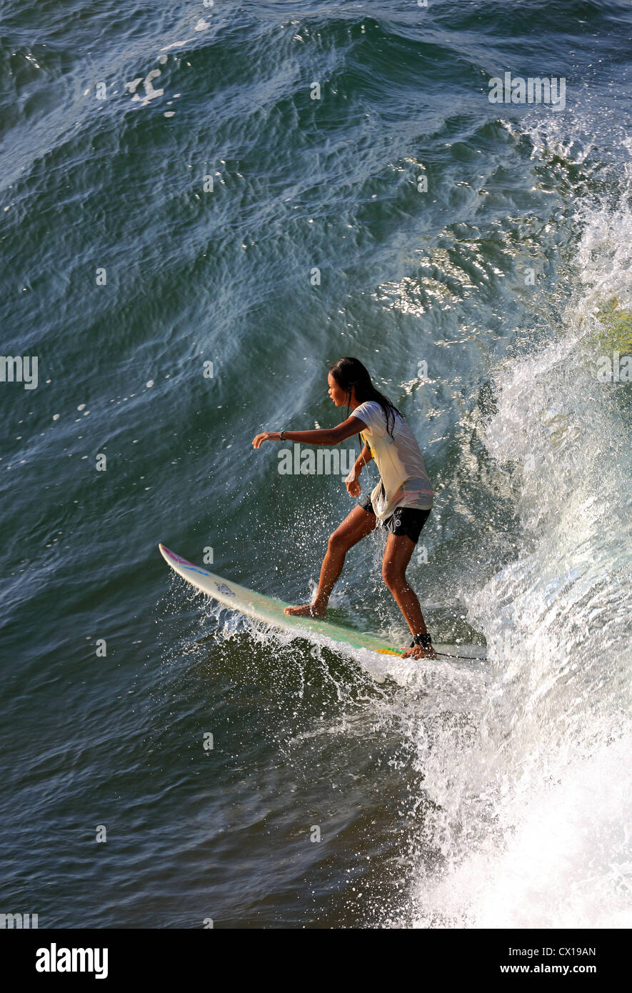 Local female surfer surfing at Batu Karas in West Java, Indonesia. Stock Photo