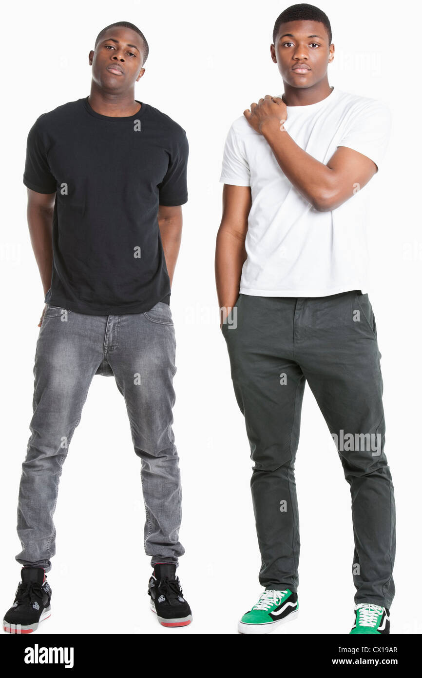 Portrait of two young men in casuals over gray background Stock Photo ...