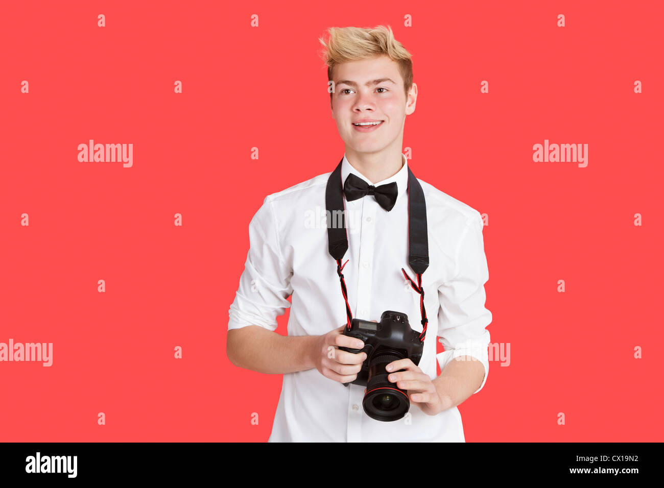 Handsome young man with digital camera over red background Stock Photo