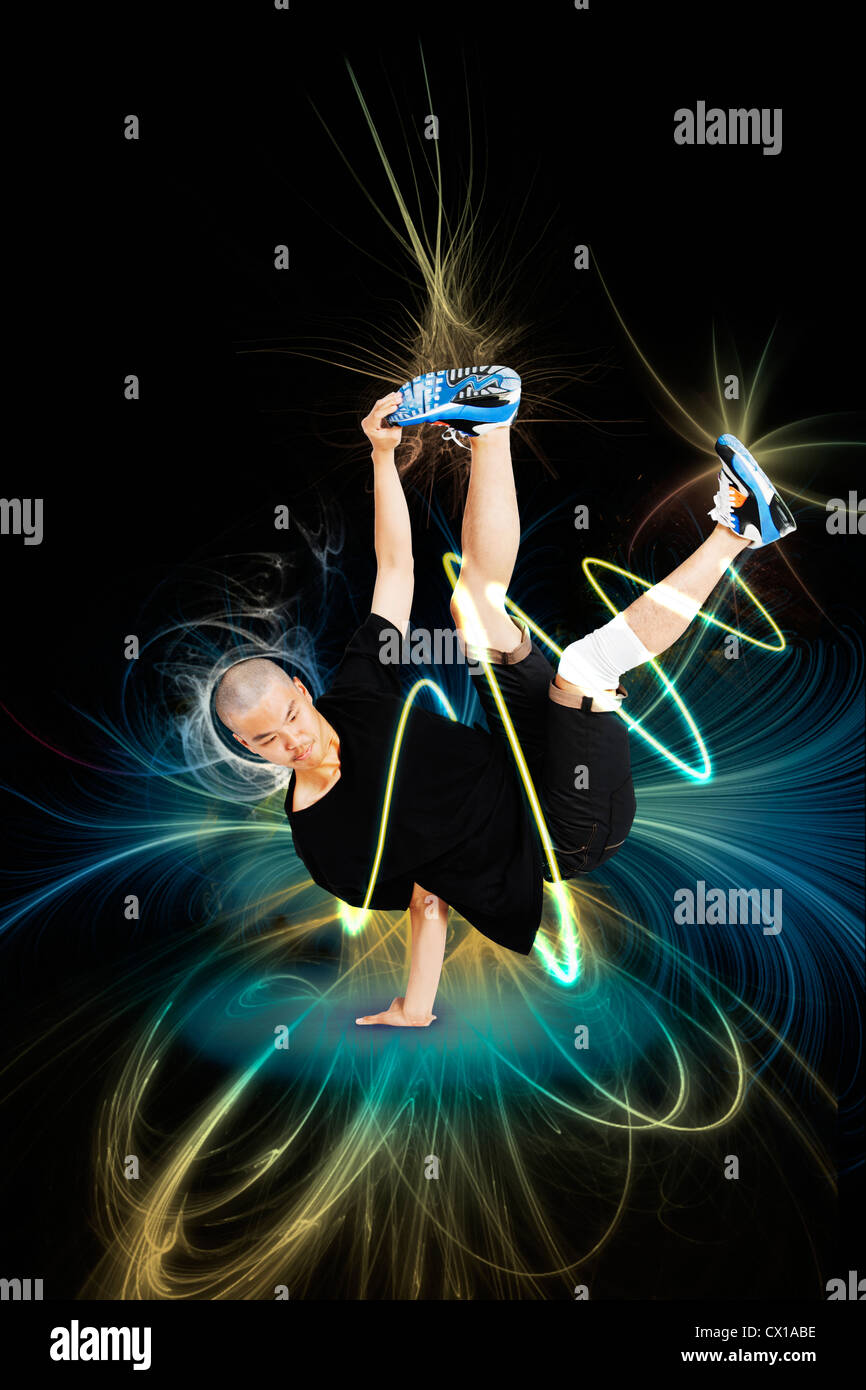 Break dancer performing handstand over blue background Stock Photo