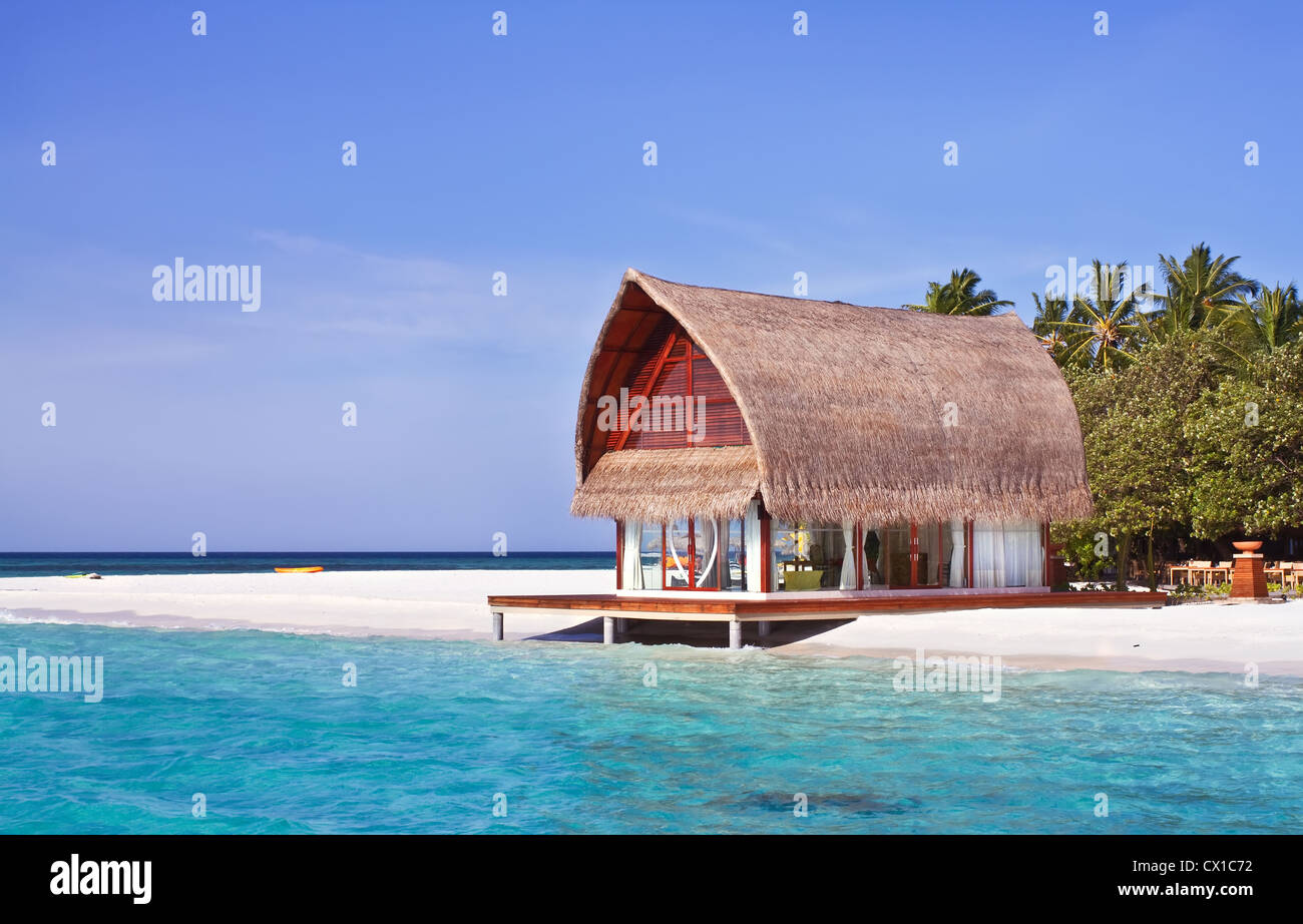 Landscape photo of beach house in Maldive ocean with blue sky Stock Photo