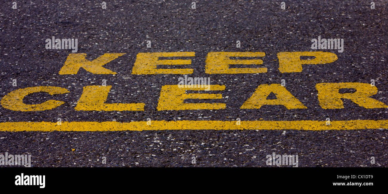 Keep Clear signed painted on a a road in yellow paint Stock Photo